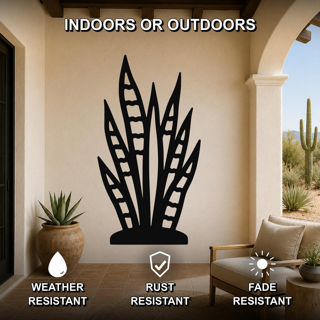 Black metal snake plant wall art with leaf cutouts, mounted on a beige outdoor patio wall above a potted plant and lounge chair.