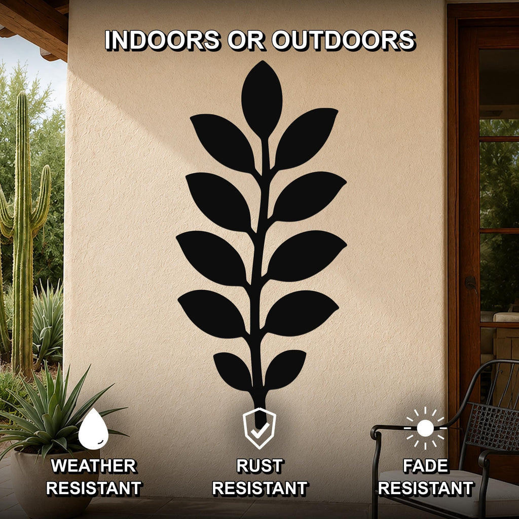 Black metal leaf wall art with a silhouette of a plant, mounted on an outdoor wall beside a patio door and potted plants.