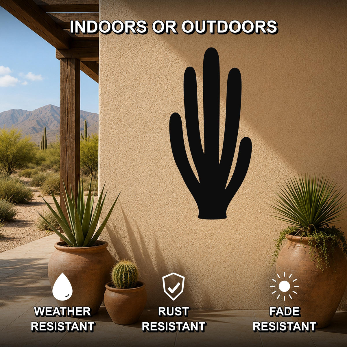 Black metal organ pipe cactus wall art silhouette mounted on a beige outdoor wall, displayed on a patio with potted plants and desert scenery in the background.