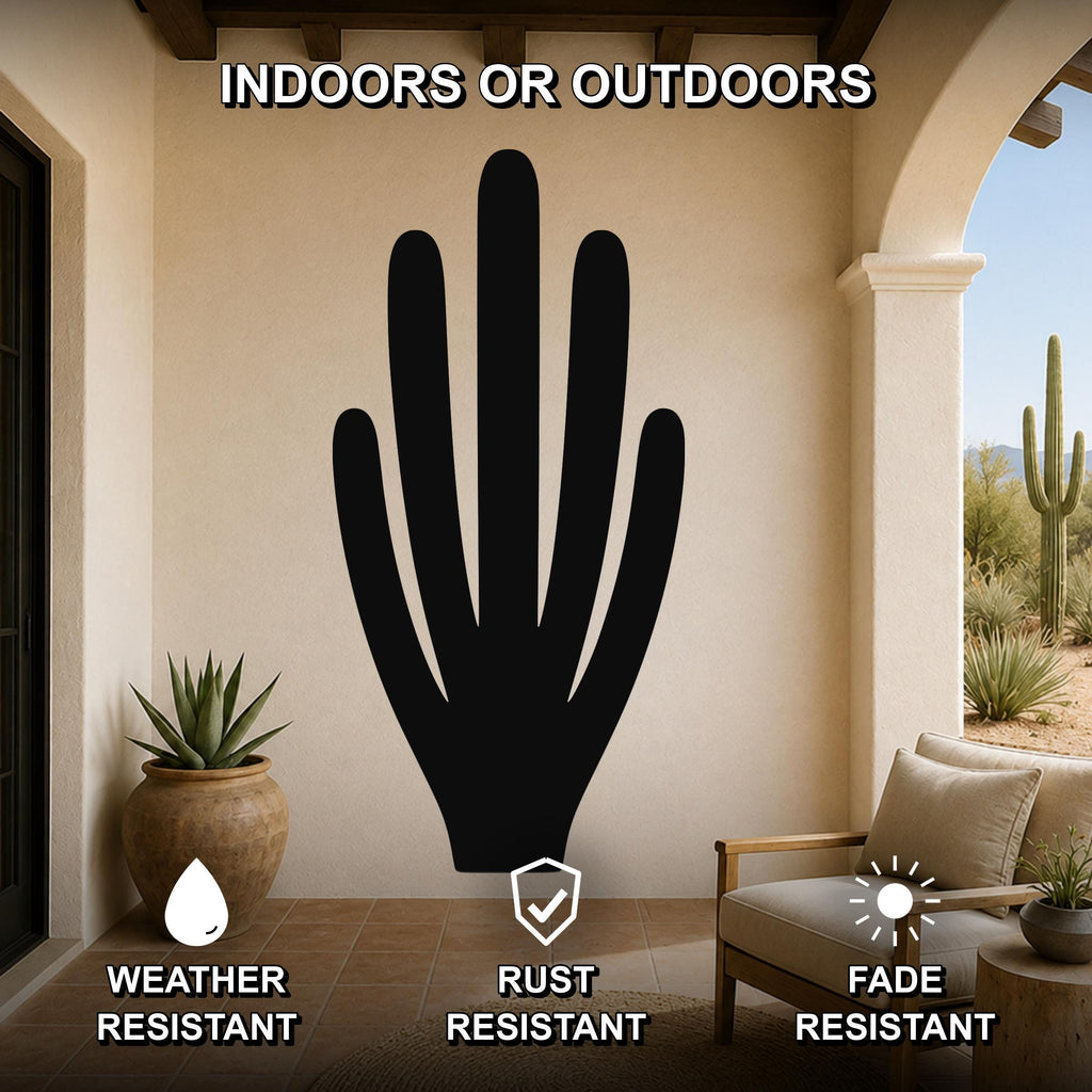 Black metal organ pipe cactus wall art with vertical spine cutouts, mounted on a beige outdoor patio wall above a wooden chair.