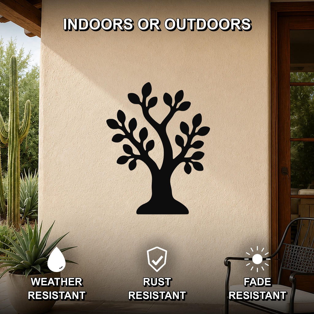 Black metal wall art in the shape of a tree silhouette, mounted on an outdoor patio wall with cacti and a chair visible nearby.