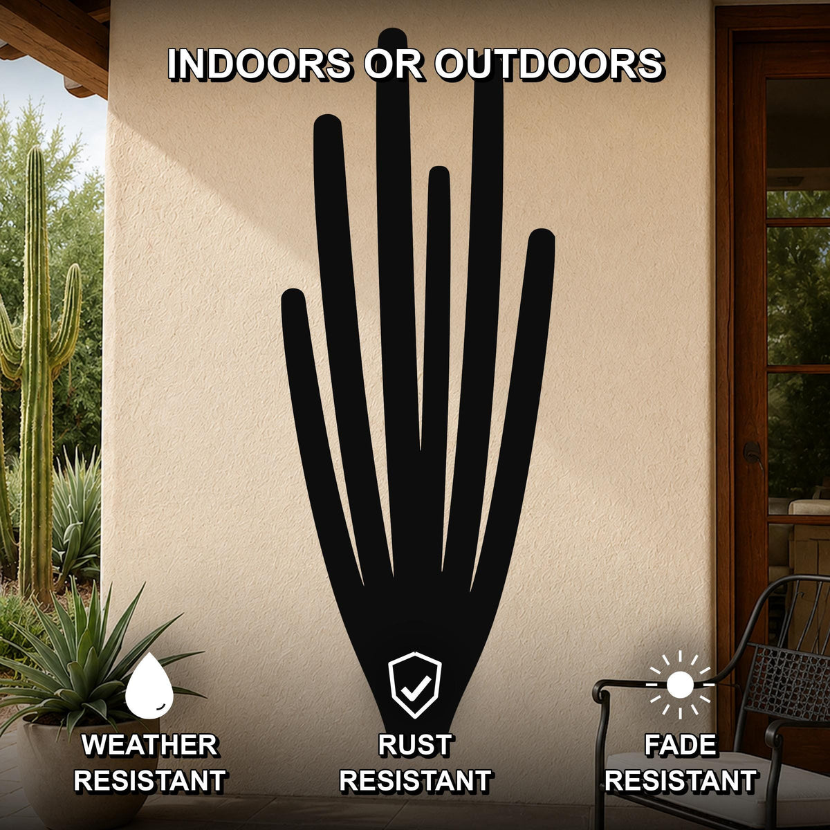 Black metal organ pipe cactus wall art with vertical spine cutouts, mounted on an outdoor patio wall above a potted plant.