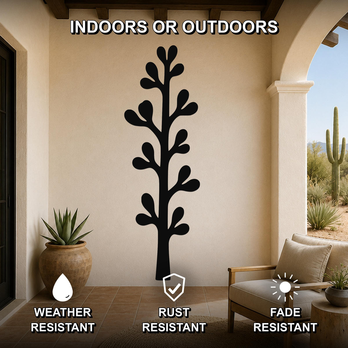 Black metal olive branch wall art with leafy cutouts, mounted on a beige outdoor patio wall above a wooden chair.