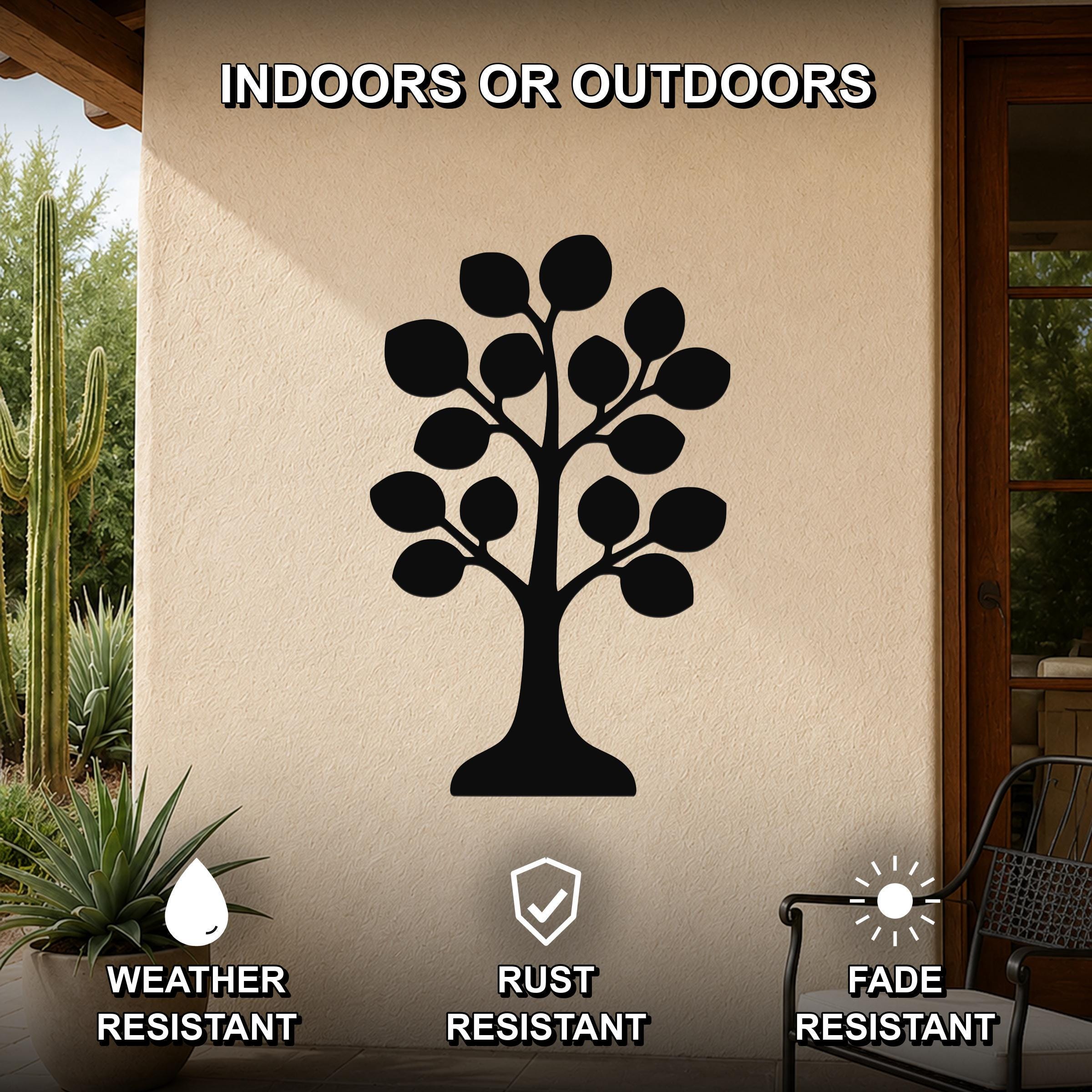 Black metal tree wall art with leaf cutouts, mounted on an outdoor patio wall beside a cactus and chair, weather, rust, and fade resistant.