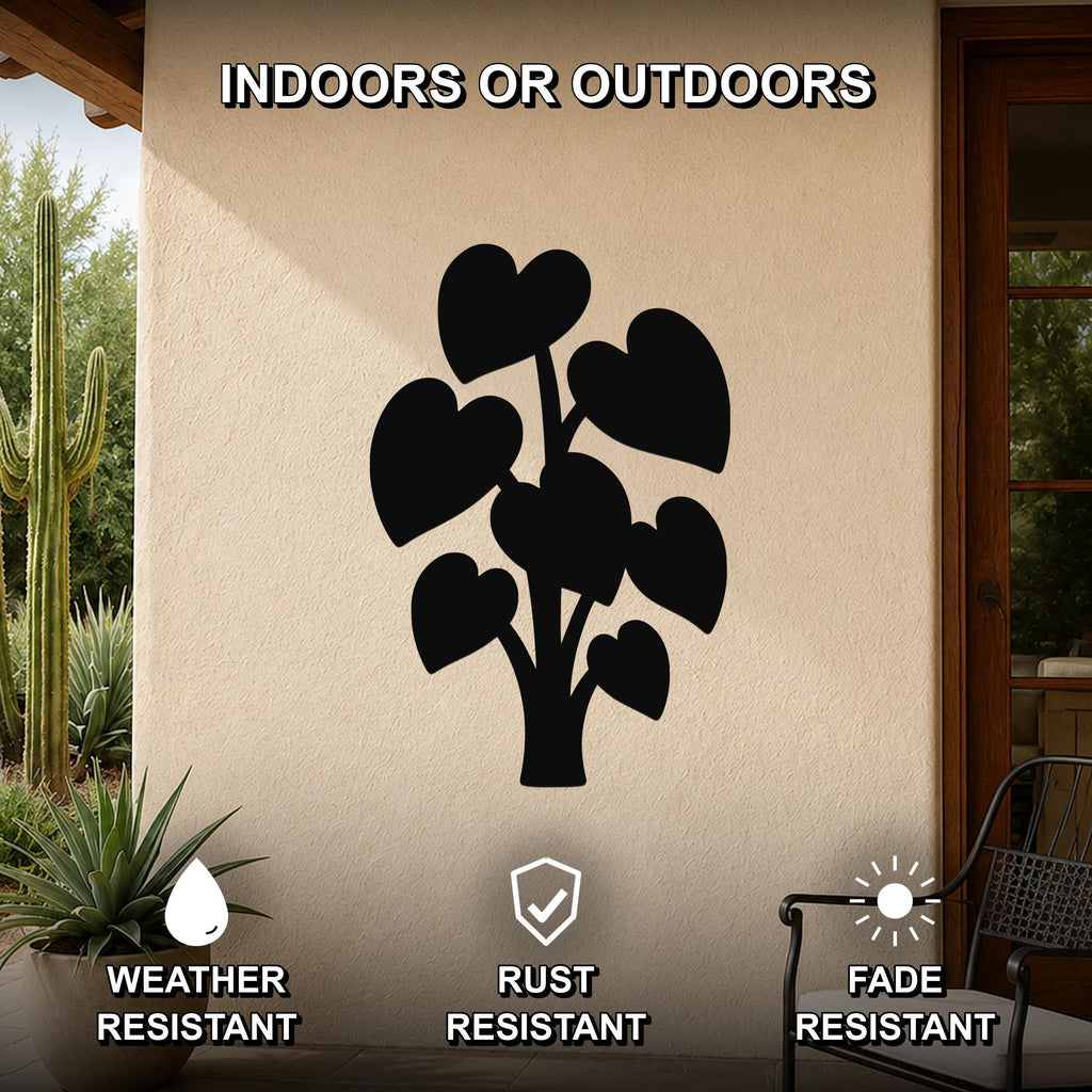 Black metal wall art in the silhouette of an elephant ear plant with heart-shaped leaves, mounted on an outdoor patio wall.