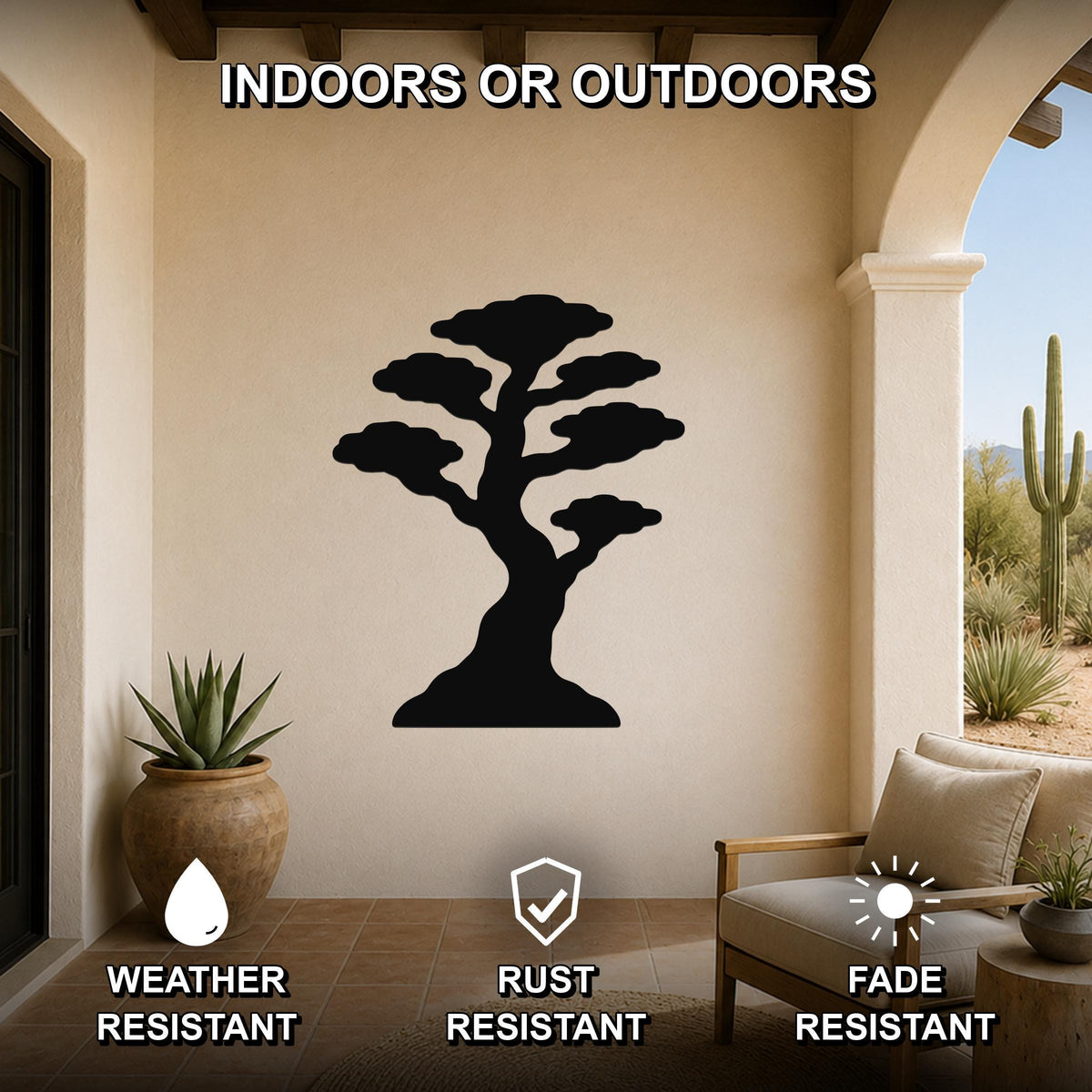 Black metal bonsai tree wall art silhouette mounted on a beige outdoor patio wall, weather resistant, rust resistant, and fade resistant, with a potted succulent and lounge chair nearby.