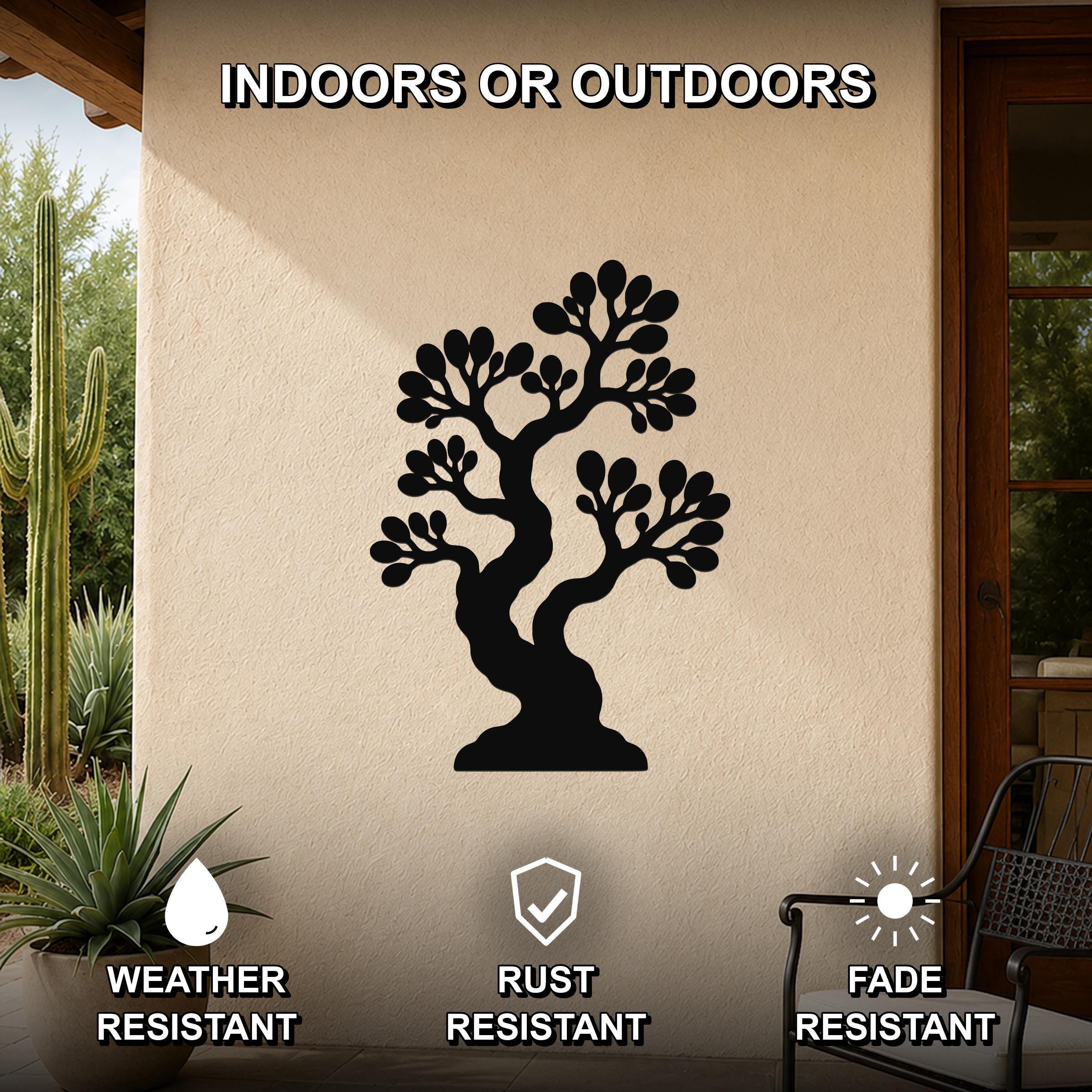 Black metal bonsai tree wall art with detailed branch cutouts, mounted on an outdoor patio wall above a potted plant.