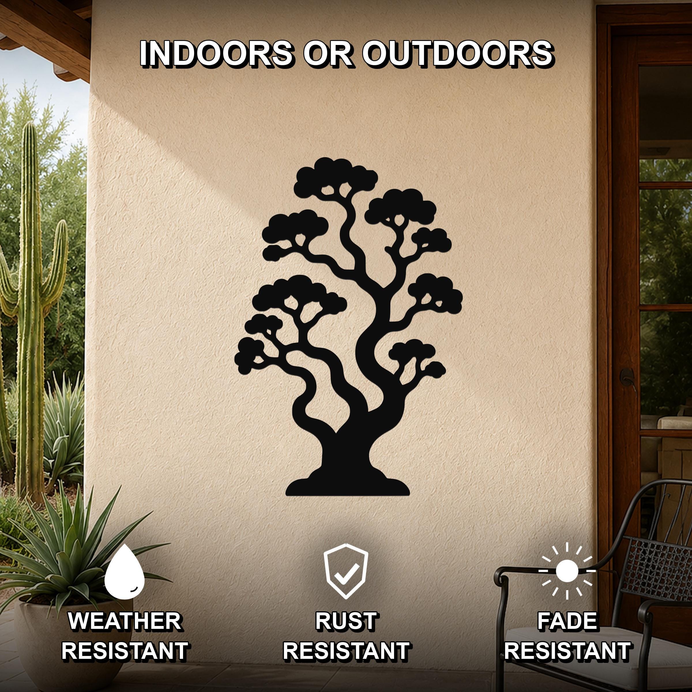 Black metal bonsai tree wall art with intricate branch cutouts, mounted on an outdoor patio wall above a potted plant.