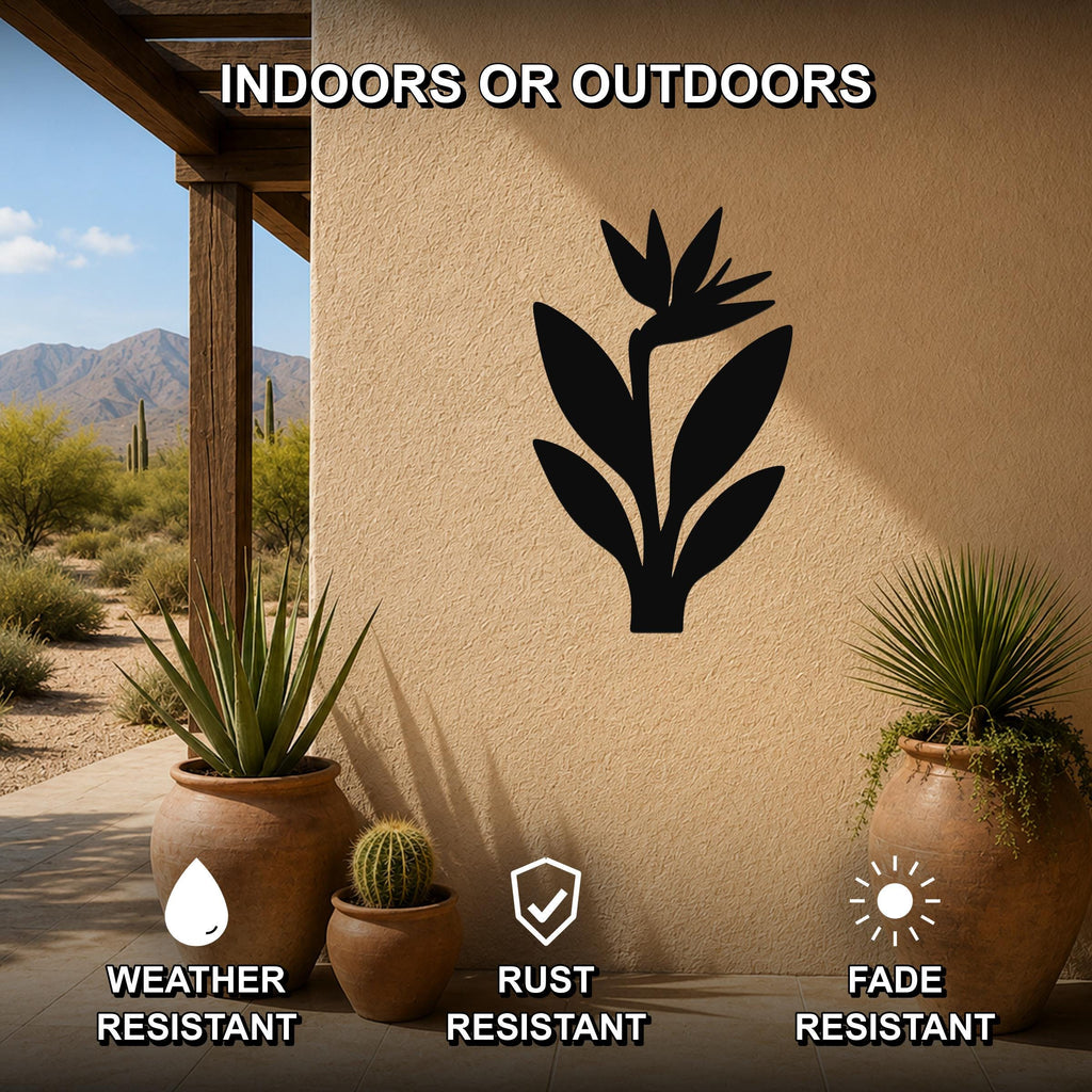 Black metal Bird of Paradise wall art silhouette mounted on an outdoor patio wall, weather resistant, rust resistant, and fade resistant, with potted plants nearby.