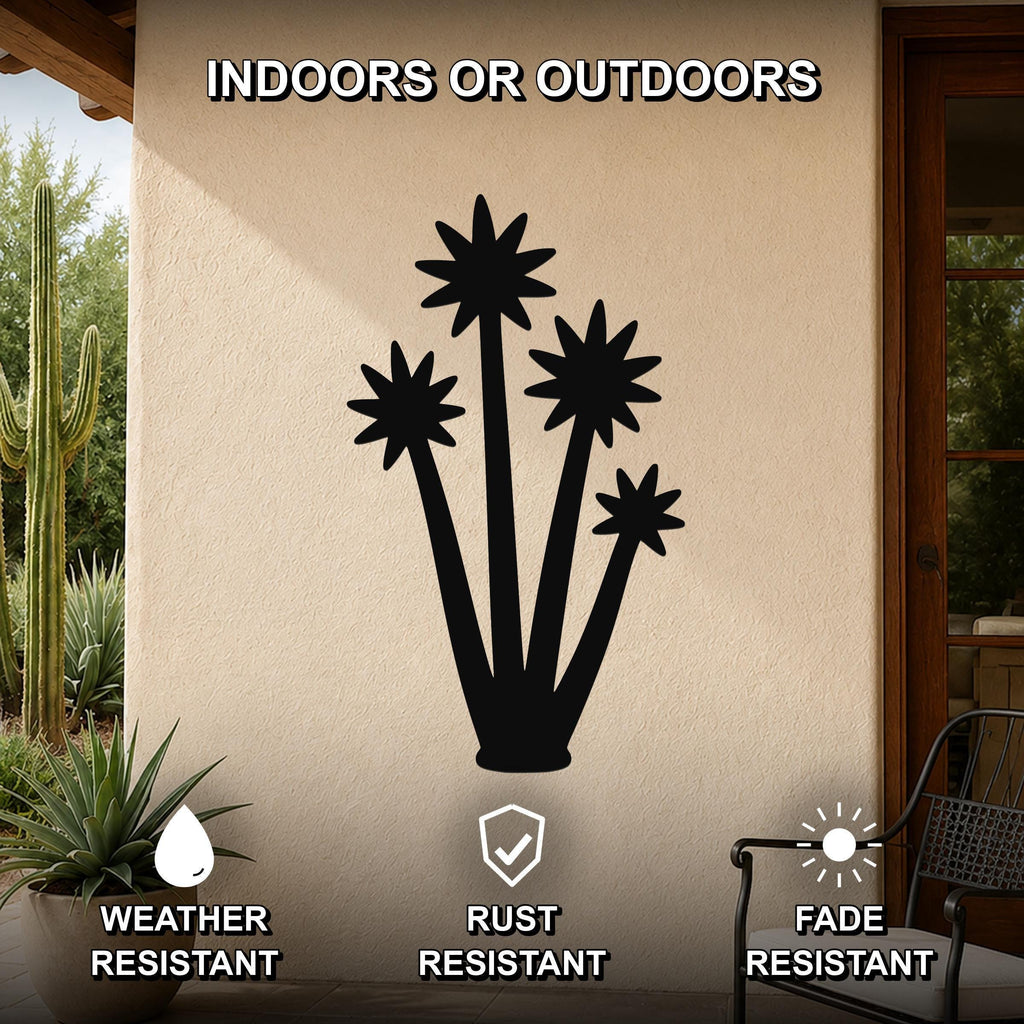 Black metal yucca wall art with star-shaped cutouts, mounted on an outdoor patio wall above a potted plant.