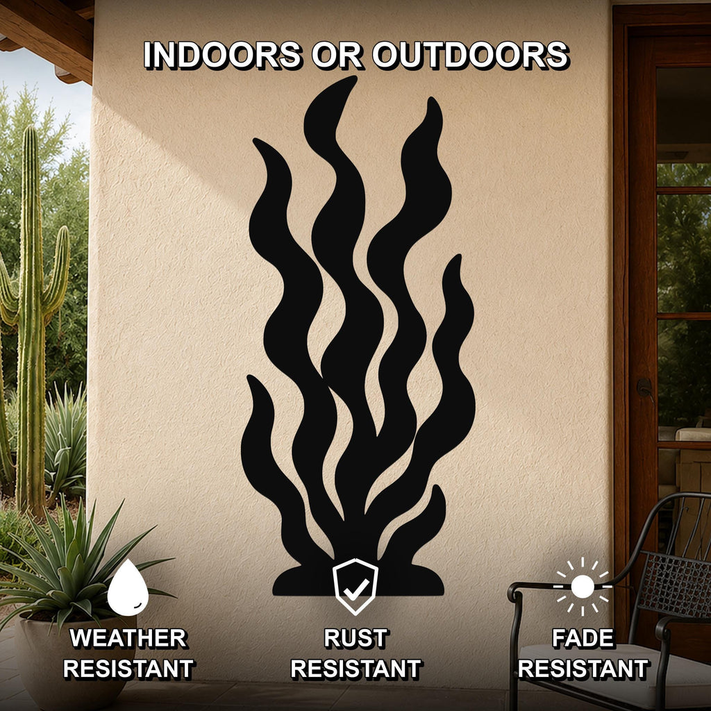 Black metal kelp wall art with wavy cutout design, mounted on an outdoor patio wall beside a potted succulent and cactus.