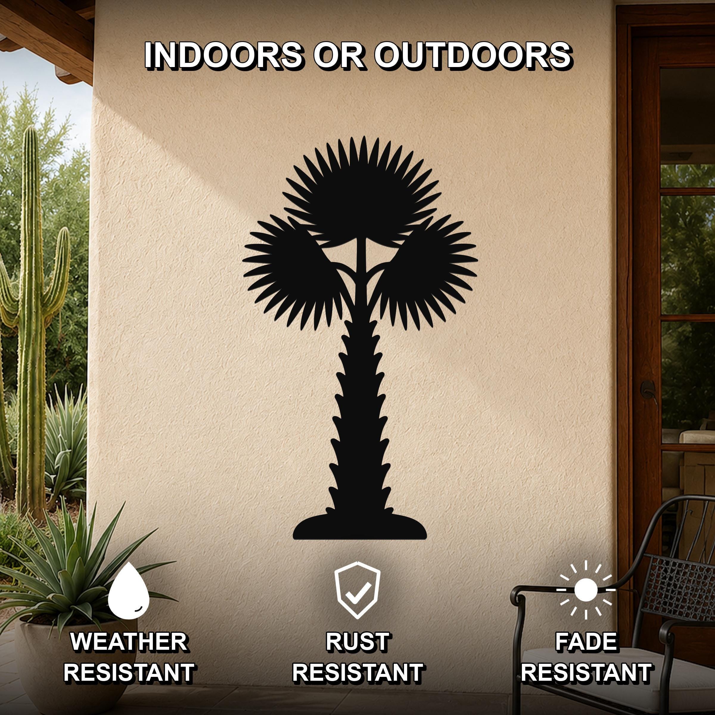Black metal palm tree wall art with fan-shaped fronds and a textured trunk, mounted on an outdoor patio wall above a potted succulent.