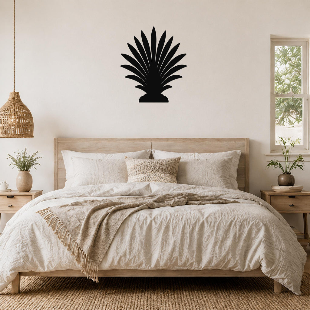 Black metal palm tree wall art with fan-shaped fronds, mounted above a wooden bed in a neutral bedroom.
