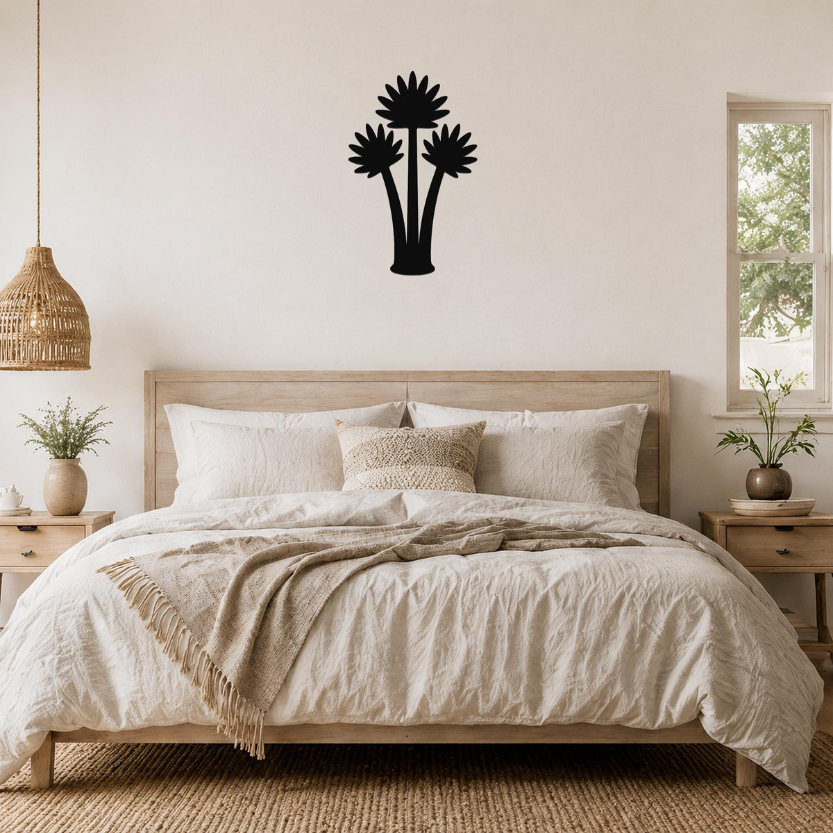Black metal fan palm tree wall art with three leafy silhouettes, mounted above a wooden bed in a neutral bedroom.