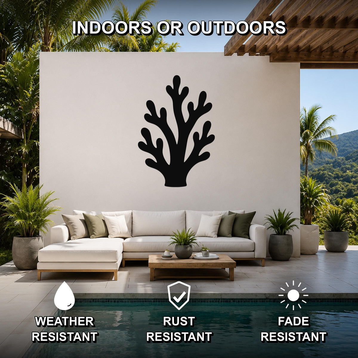 Black metal branching coral wall art with cutout design, mounted on a white outdoor patio wall above a sofa near a pool.