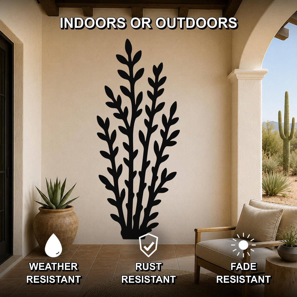 Black metal wall art with a leafy branch silhouette, mounted on a beige outdoor patio wall above a wooden chair and potted plant.