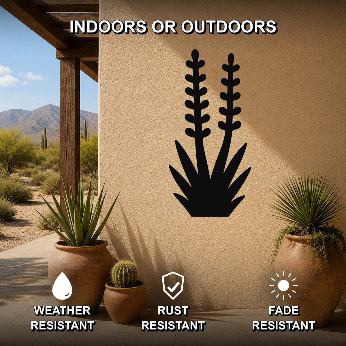 Black metal yucca wall art silhouette with layered leaf and bloom cutouts, mounted on a stucco outdoor wall above potted desert plants on a patio.