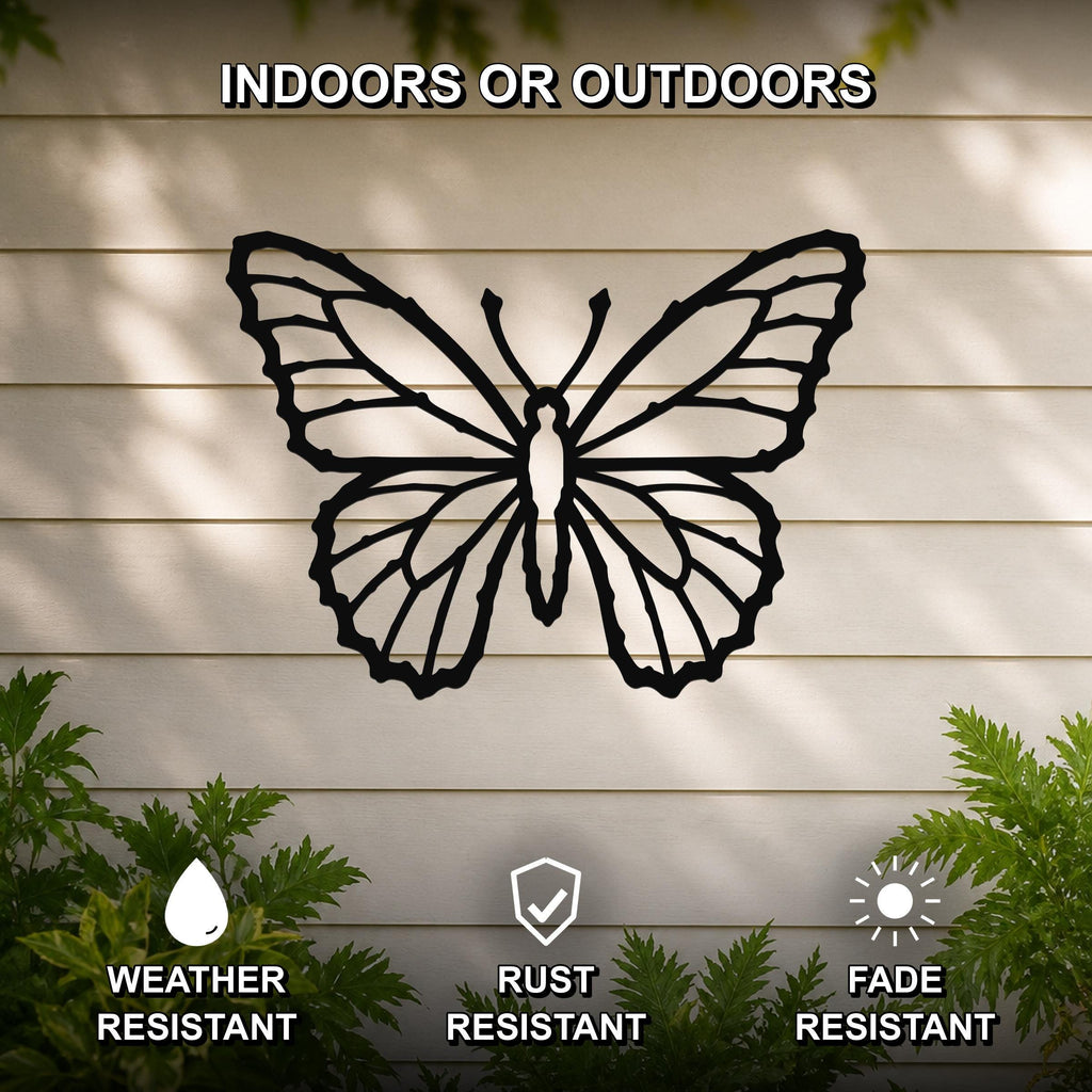 Black metal butterfly wall art with detailed wing cutouts, mounted on a light-colored outdoor wall with greenery, weather, rust, and fade resistant.