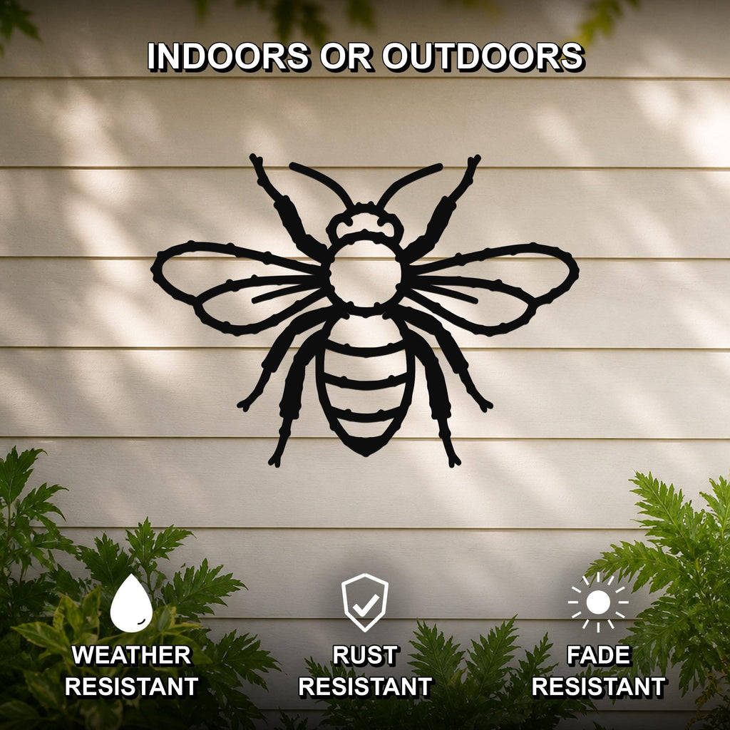 Black metal honey bee wall art with detailed cutout wings and body, mounted on a light-colored outdoor wall with greenery, weather, rust, and fade resistant.