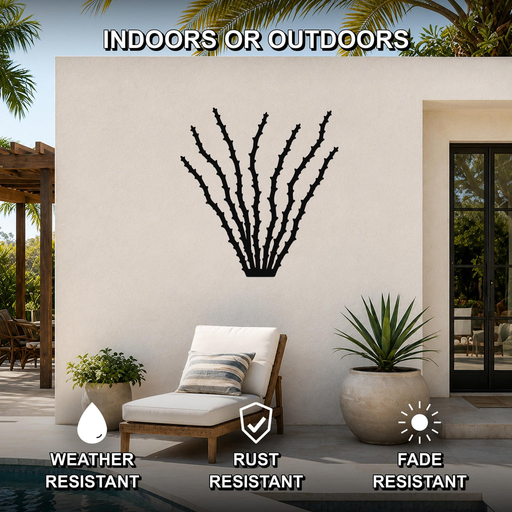 Black metal ocotillo wall art with spiky branch cutouts, mounted on an outdoor patio wall above a lounge chair.