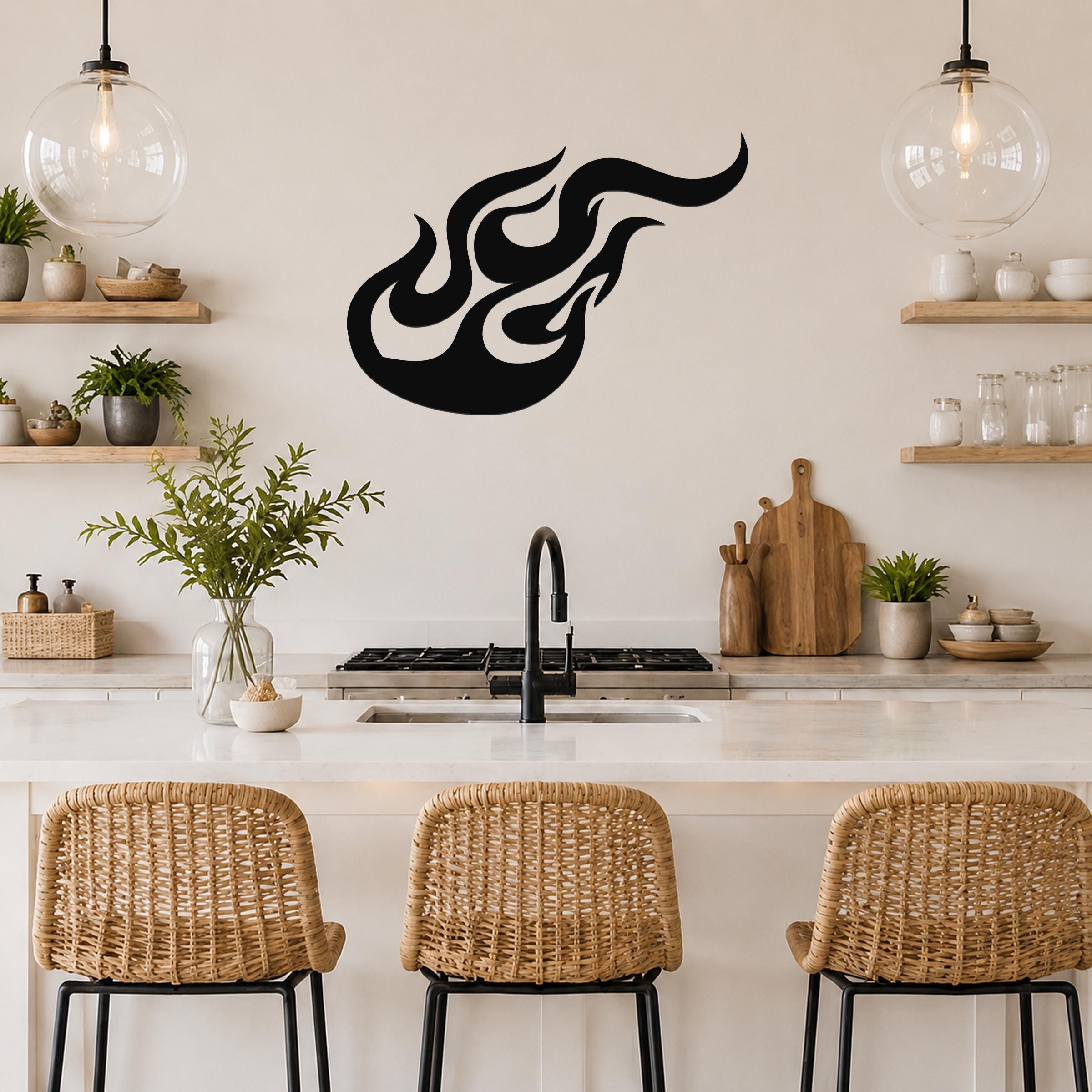 Black metal flame wall art with flowing silhouette cutouts, mounted above a kitchen counter.