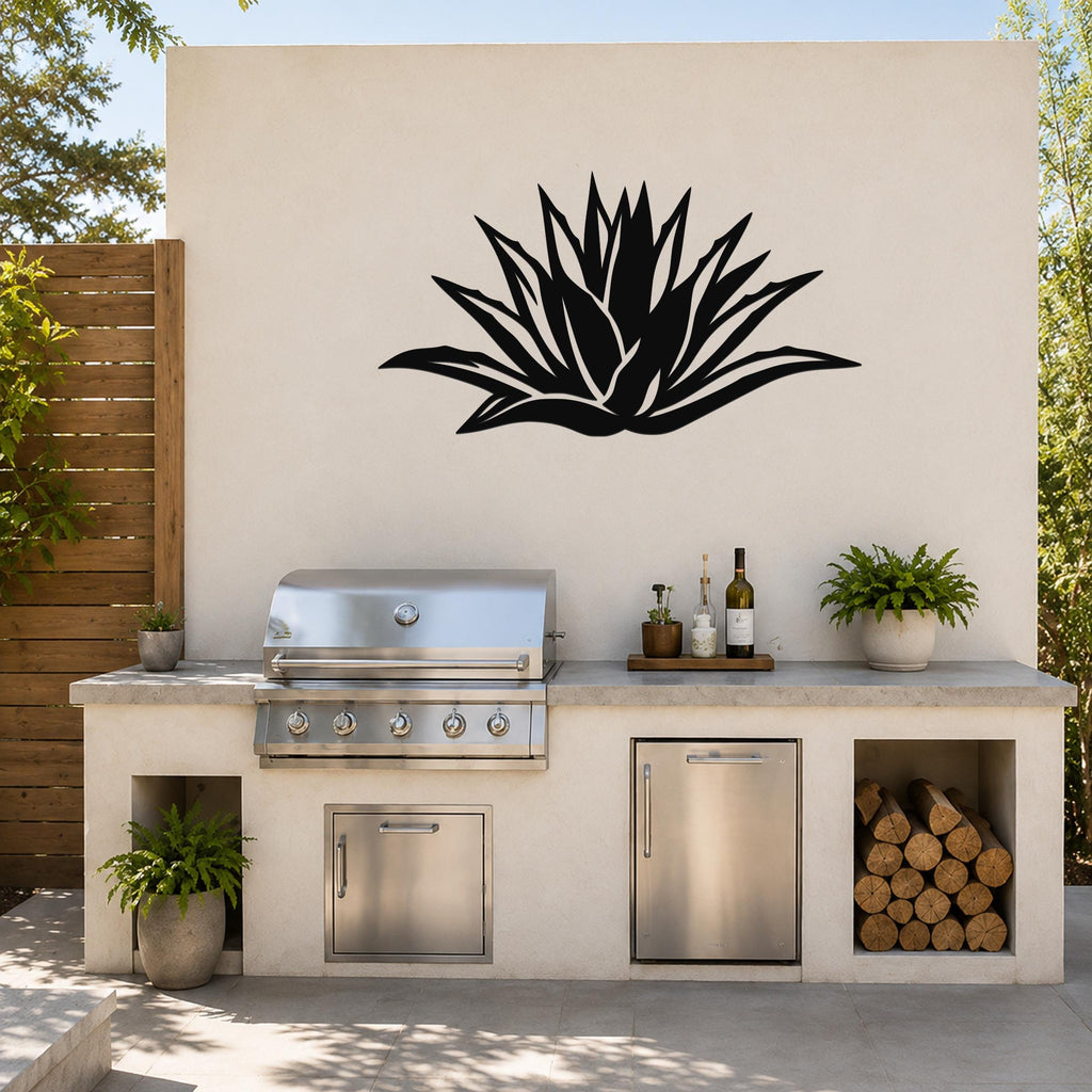Black metal agave wall art with spiky leaf cutouts, mounted on a light-colored outdoor wall above a kitchen counter.
