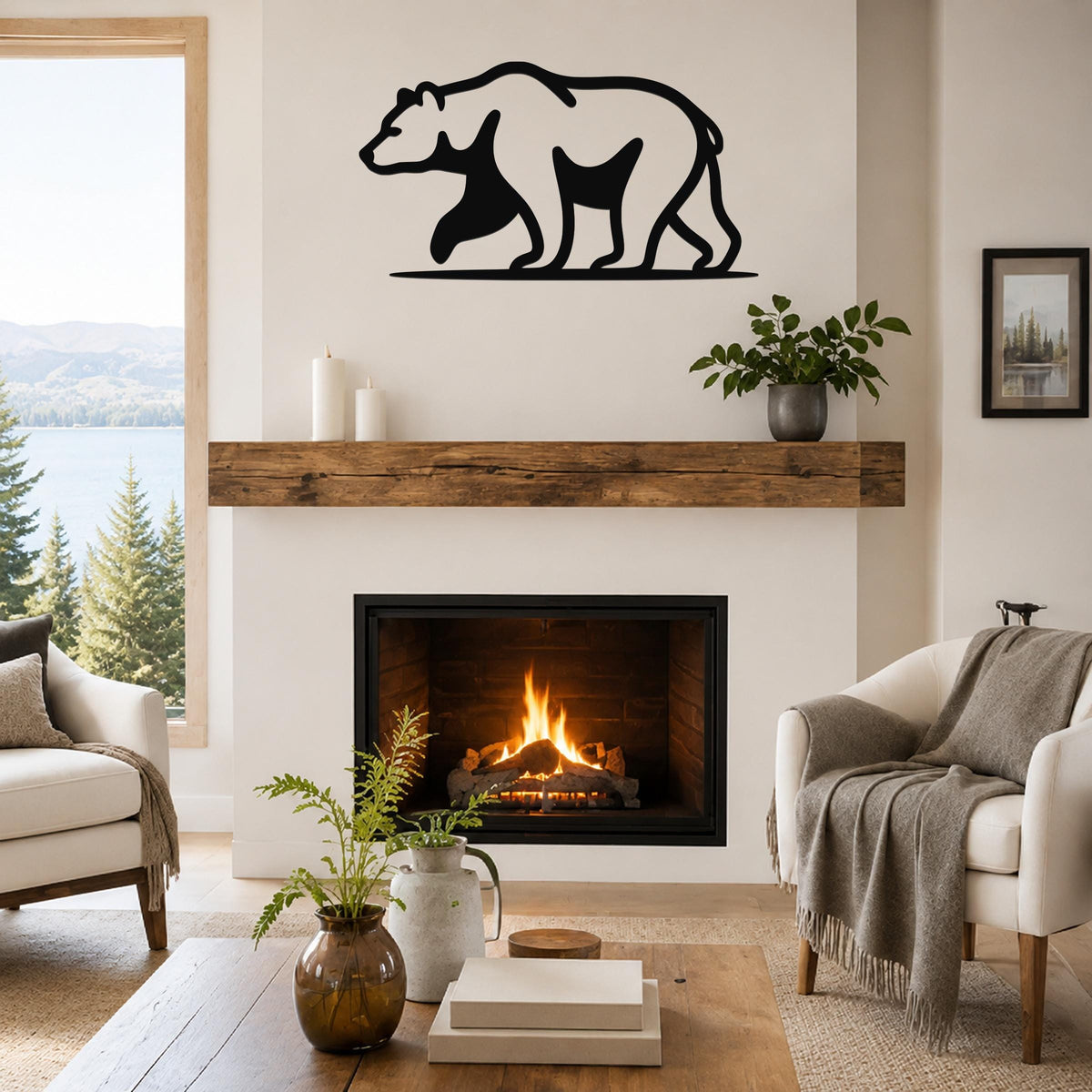 Black metal bear silhouette wall art mounted above a fireplace in a living room with a view of a lake and mountains.