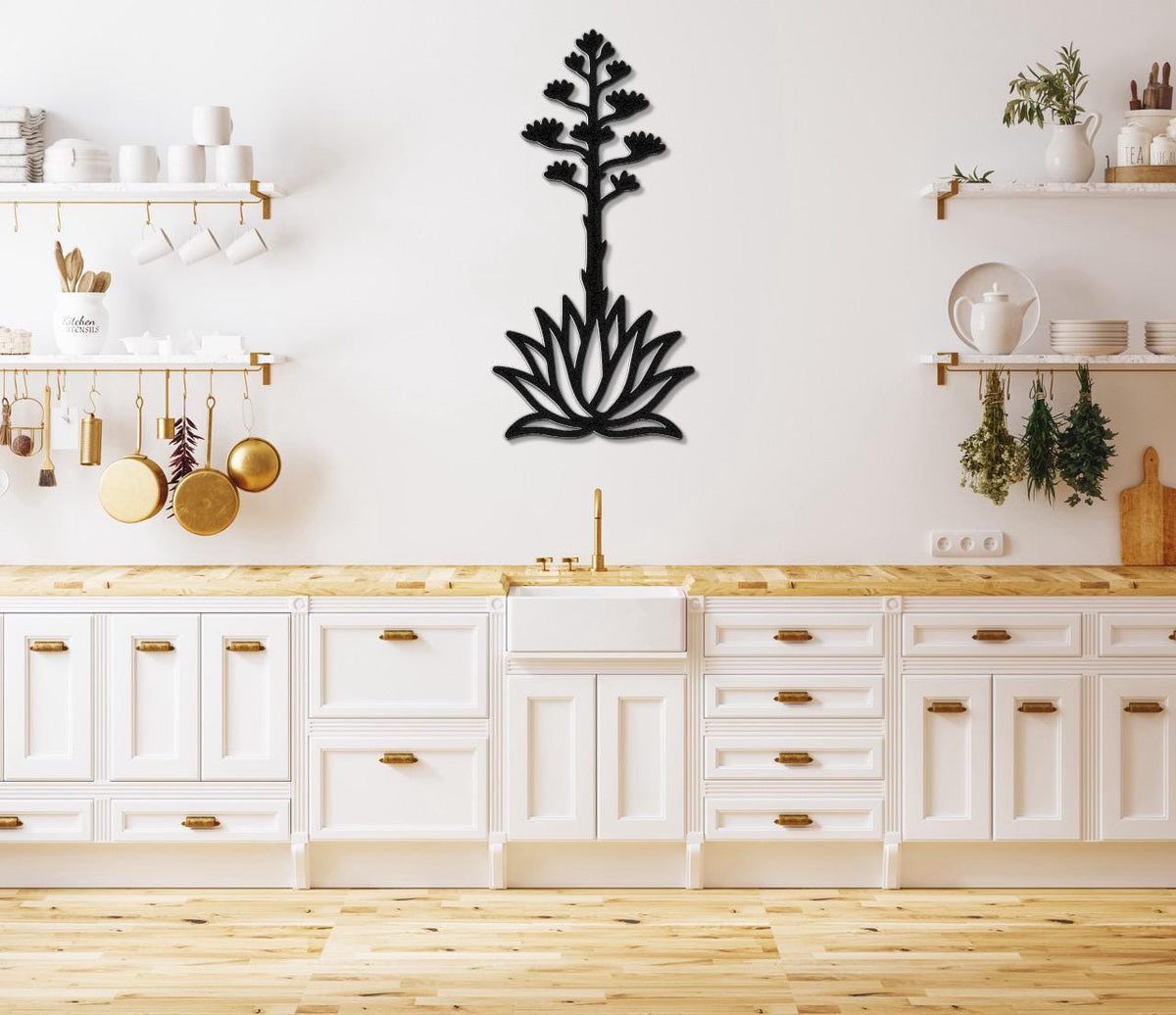 Black metal agave wall art with a blooming flower and leaf cutout design, mounted on a kitchen wall above a wooden countertop.