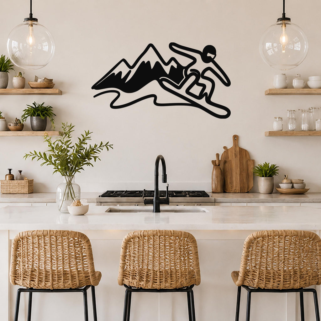 Black metal wall art silhouette of a snowboarder in motion above a kitchen counter, mounted on a light-colored wall between two glass pendant lights.