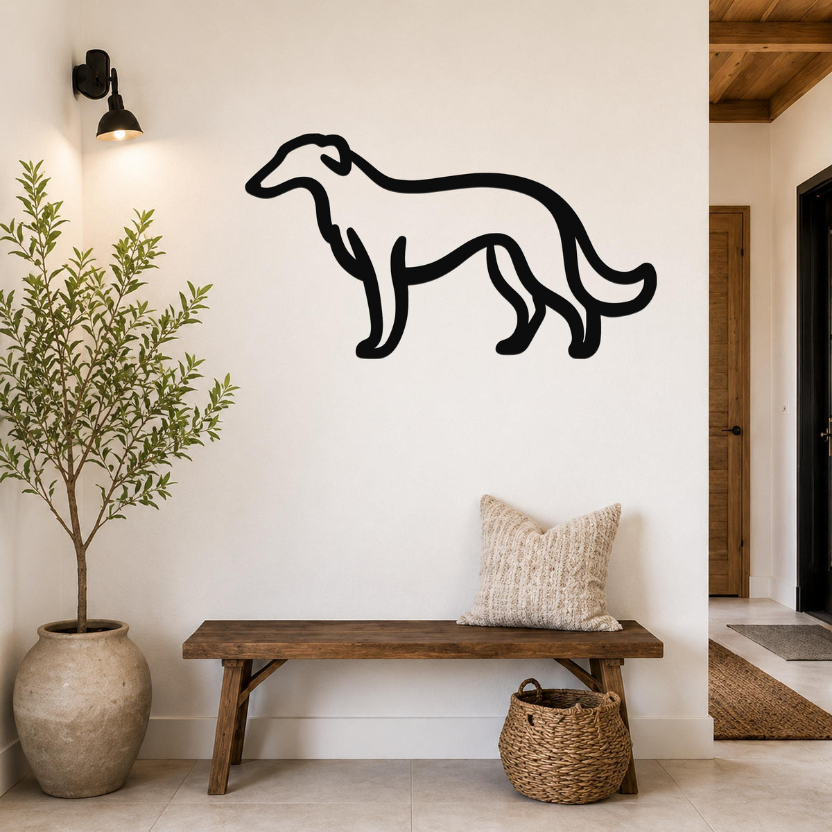 Black metal Borzoi dog wall art silhouette mounted on a white wall above a wooden bench in a hallway.