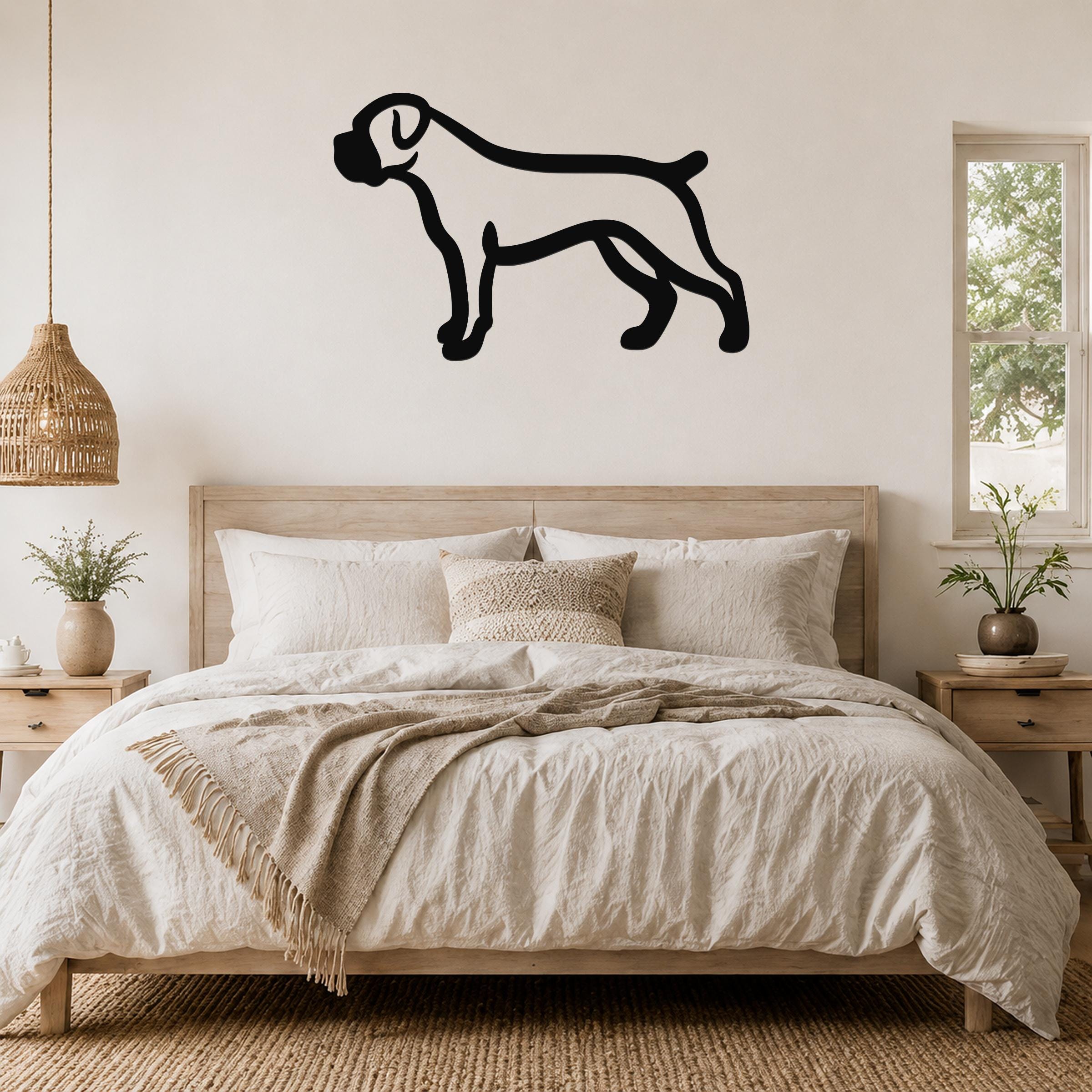 Black metal Boxer dog silhouette wall art mounted above a wooden bed in a neutral bedroom.