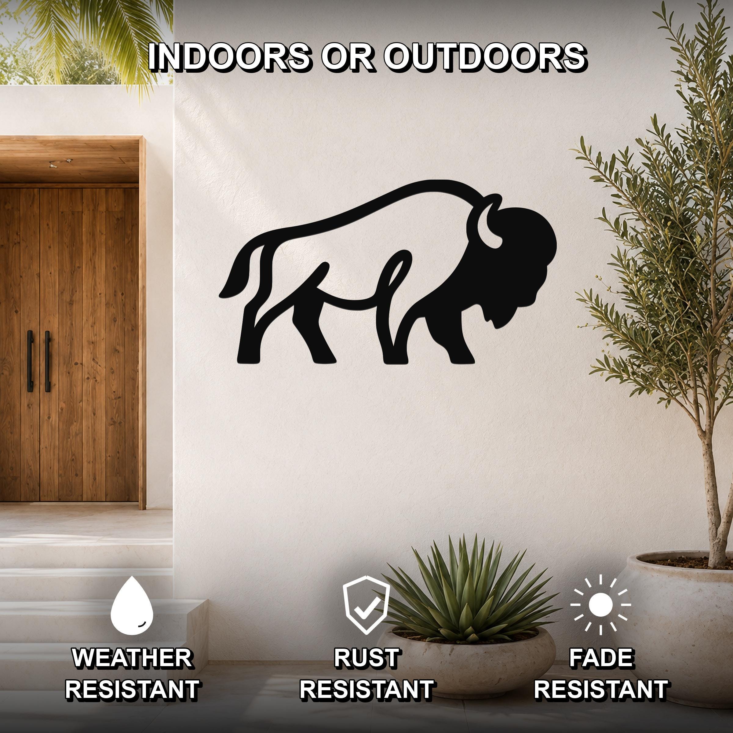 Black metal bison silhouette wall art mounted on a white exterior wall, displayed outdoors near a wooden door and potted plants.