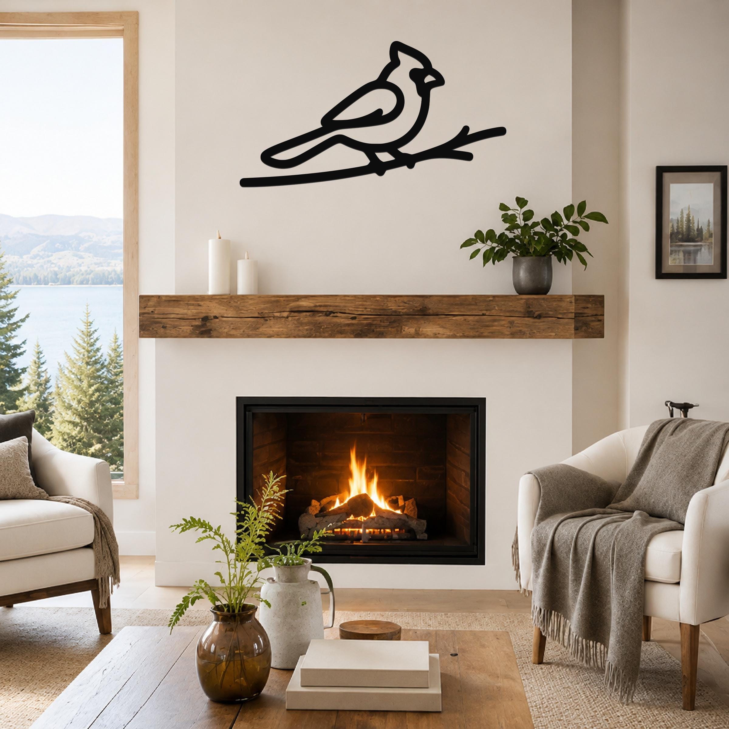 Black metal cardinal wall art in a minimalist silhouette, perched on a branch, mounted above a fireplace in a living room.