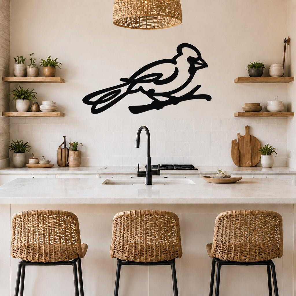 Black metal cardinal wall art in a minimalist silhouette style, mounted on a kitchen wall above a counter with wicker bar stools.
