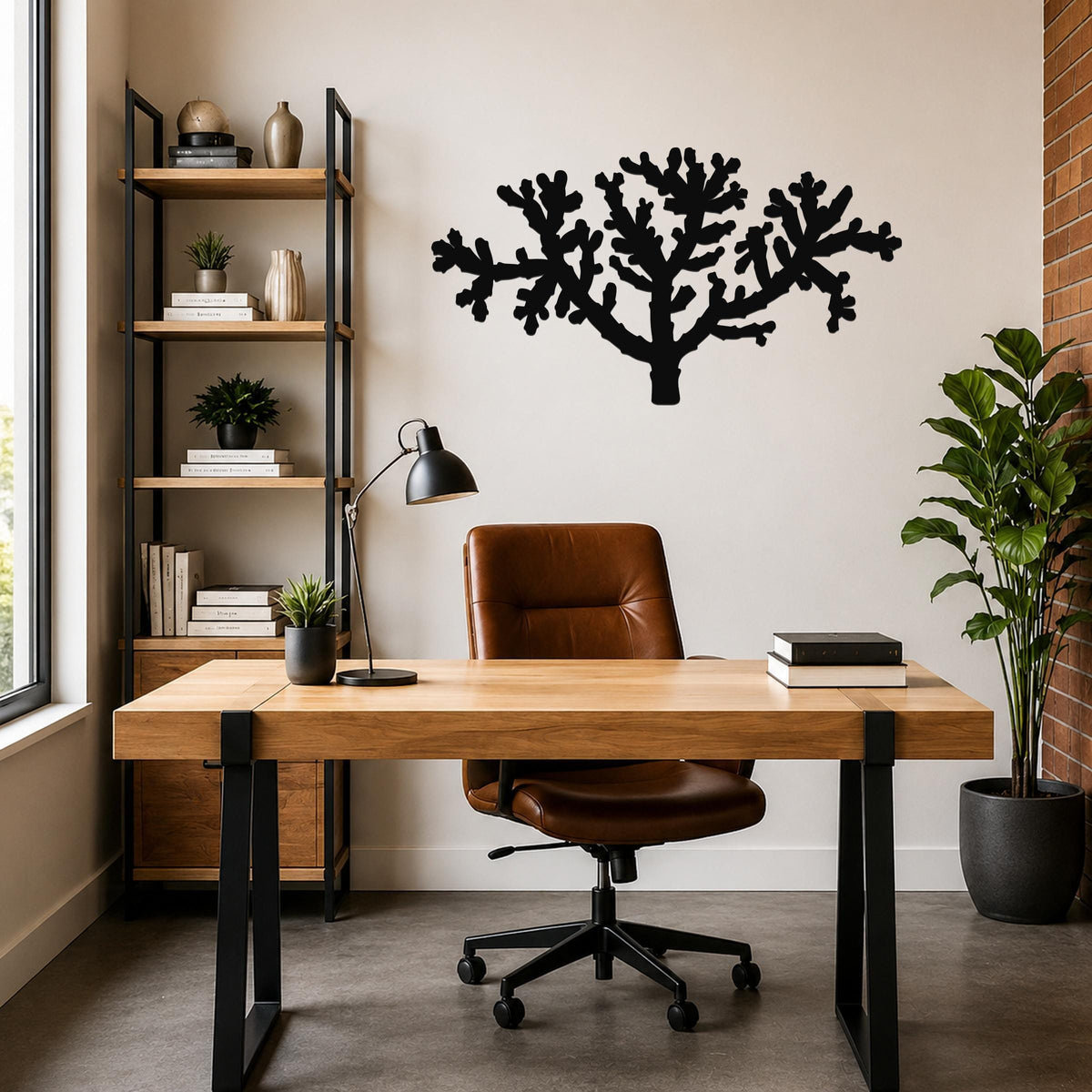 Black metal Cholla cactus wall art with branching cutout design, mounted on a wall above a wooden desk in a home office.
