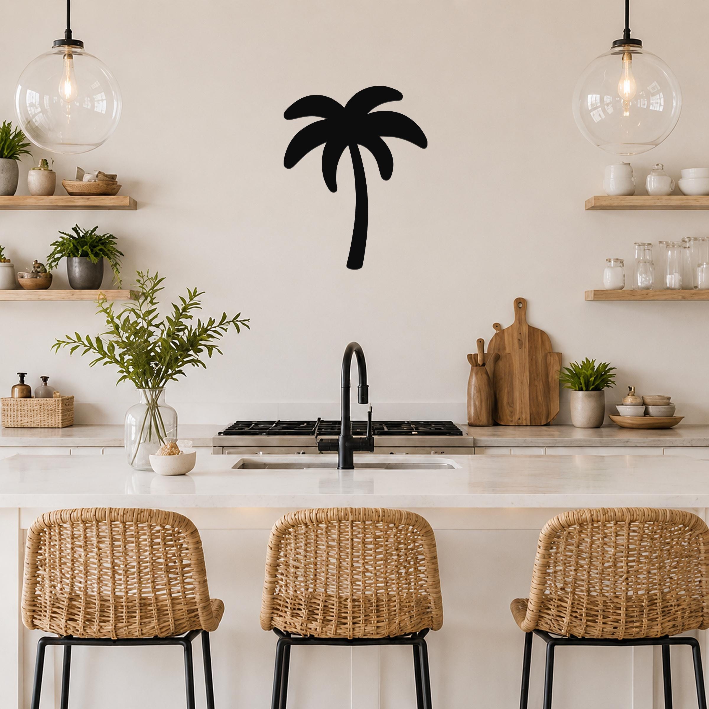 Black metal palm tree wall art with a silhouette design, mounted on a kitchen wall above a counter.