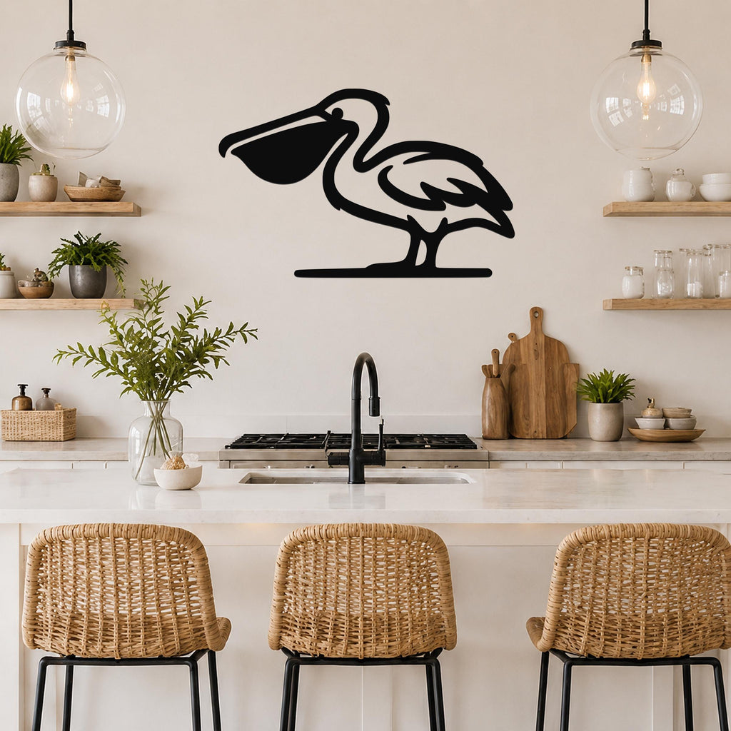 Black metal pelican wall art silhouette mounted above a kitchen counter, featuring a cutout design of a standing pelican with a long beak, in a coastal-style kitchen with wooden shelves and pendant lights.