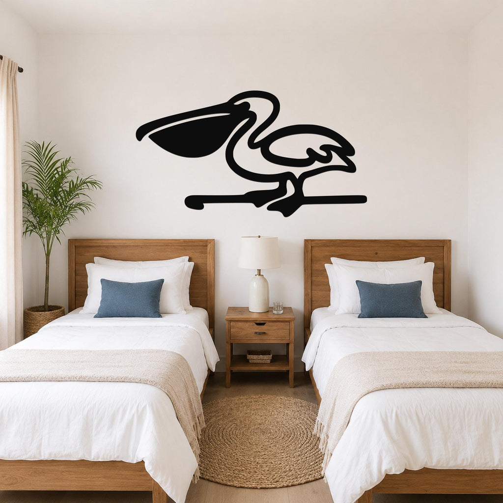 Black metal pelican wall art with a silhouette design, mounted above two beds in a coastal-style bedroom.