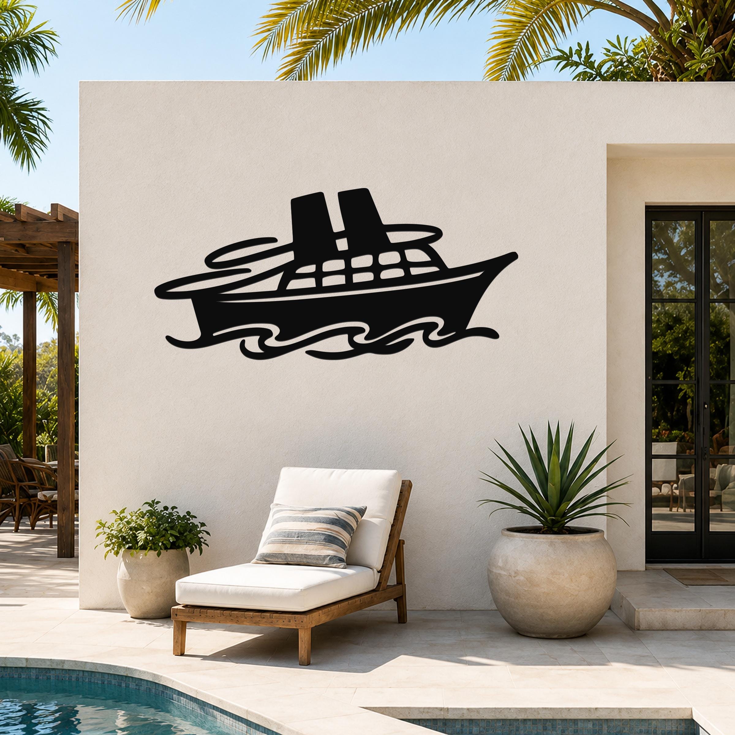 Black metal cruise ship wall art with wave cutouts, mounted on an outdoor patio wall above a lounge chair.