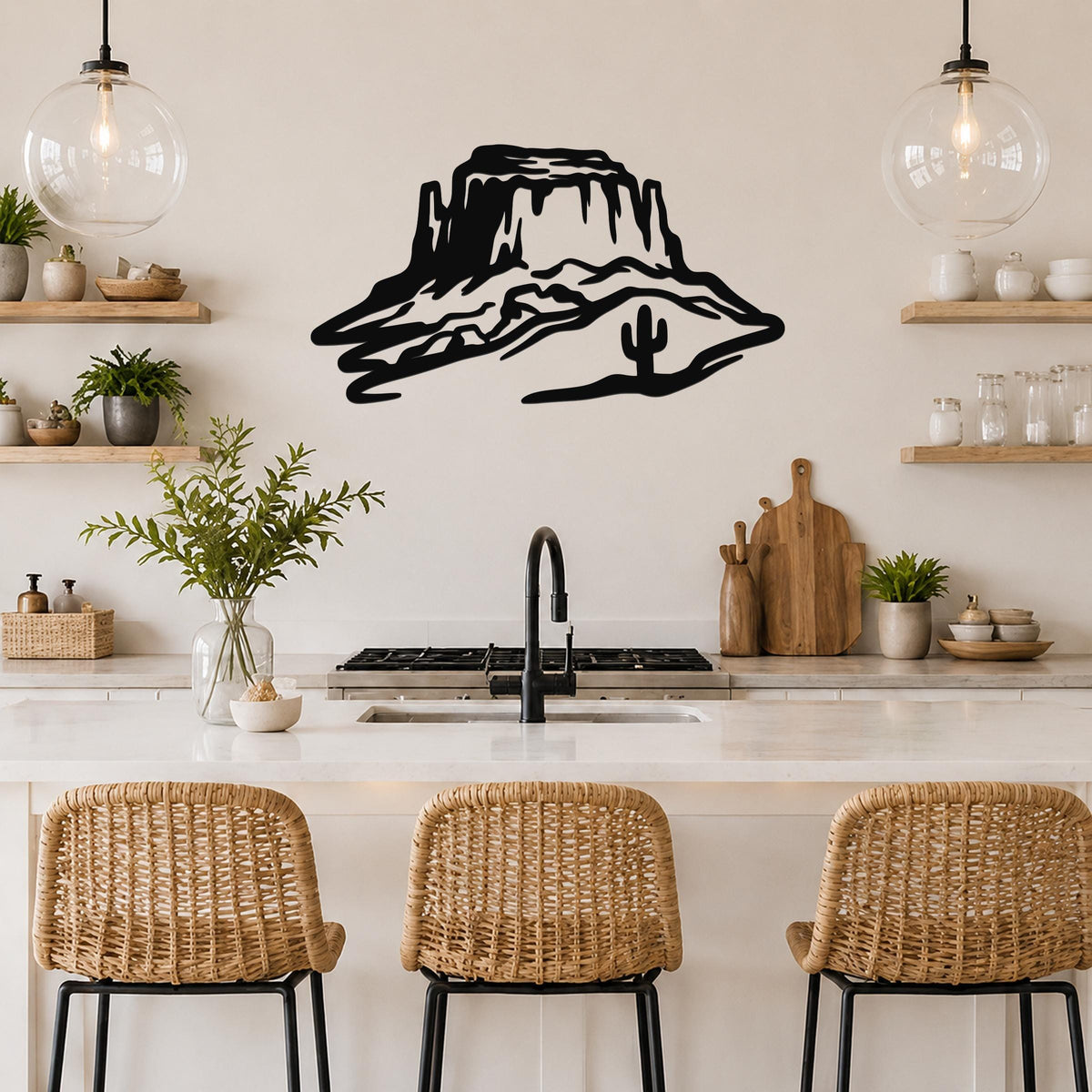 Black metal wall art silhouette of a desert mesa with a cactus, mounted above a kitchen counter.
