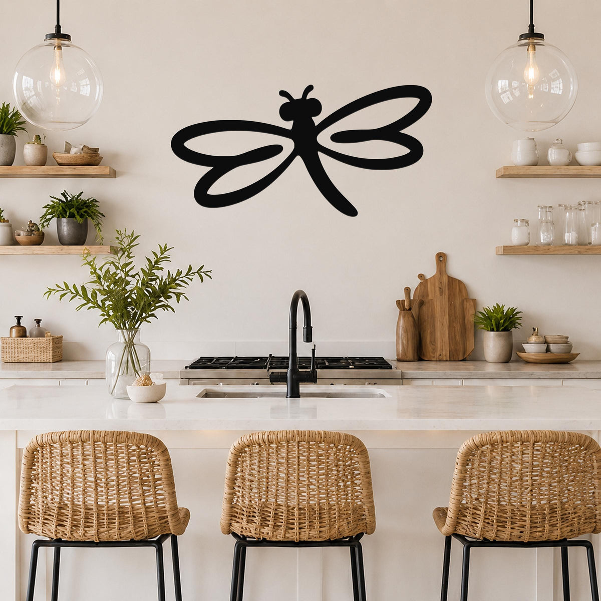 Black metal dragonfly wall art with flowing wing cutouts, mounted on a kitchen wall above a counter.