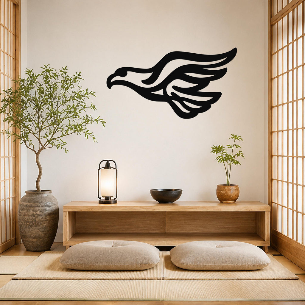 Black metal eagle wall art with flowing wing cutouts, mounted on a light-colored wall above a wooden console in a minimalist room.
