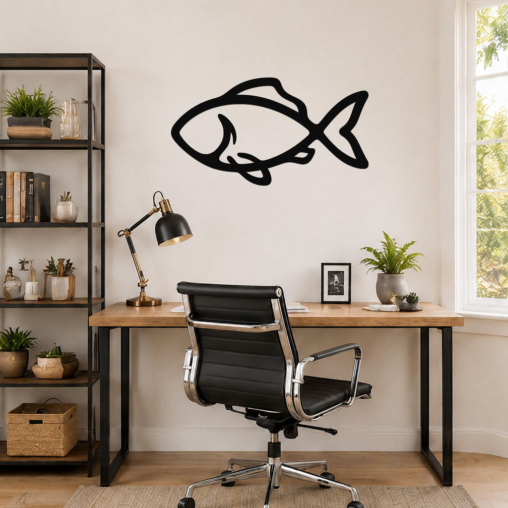 Black metal fish wall art with bold silhouette lines, mounted on a wall above a wooden desk in a home office.
