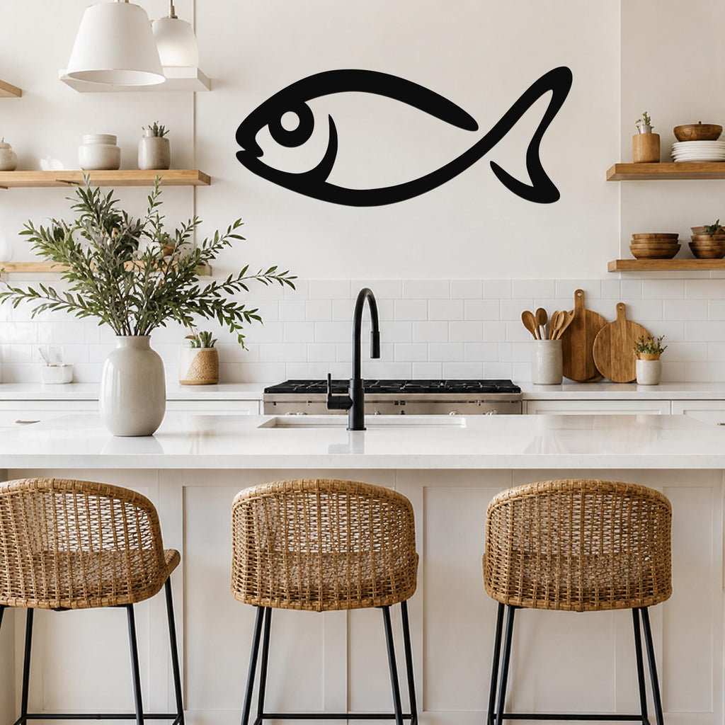 Black metal fish wall art with a bold silhouette design, mounted on a kitchen wall above a white countertop.