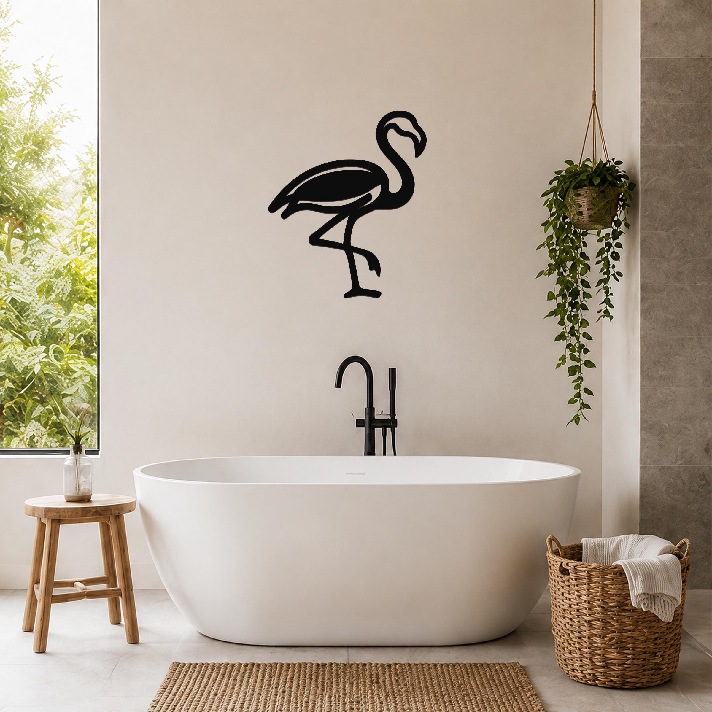 Black metal flamingo wall art silhouette mounted on a bathroom wall above a freestanding tub.