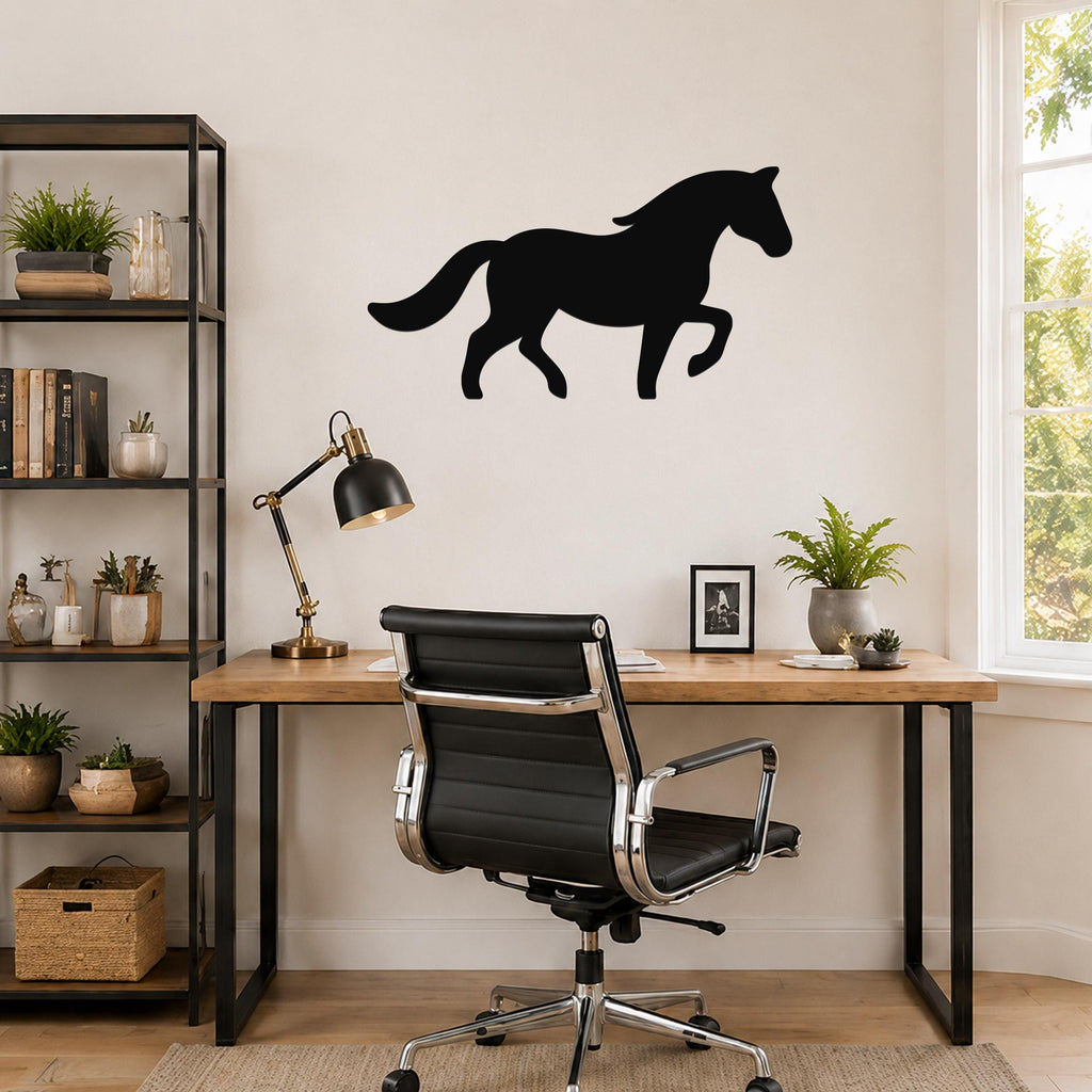 Black metal horse silhouette wall art mounted above a wooden desk in a home office, showing the horse in a walking pose with a flowing mane and tail.