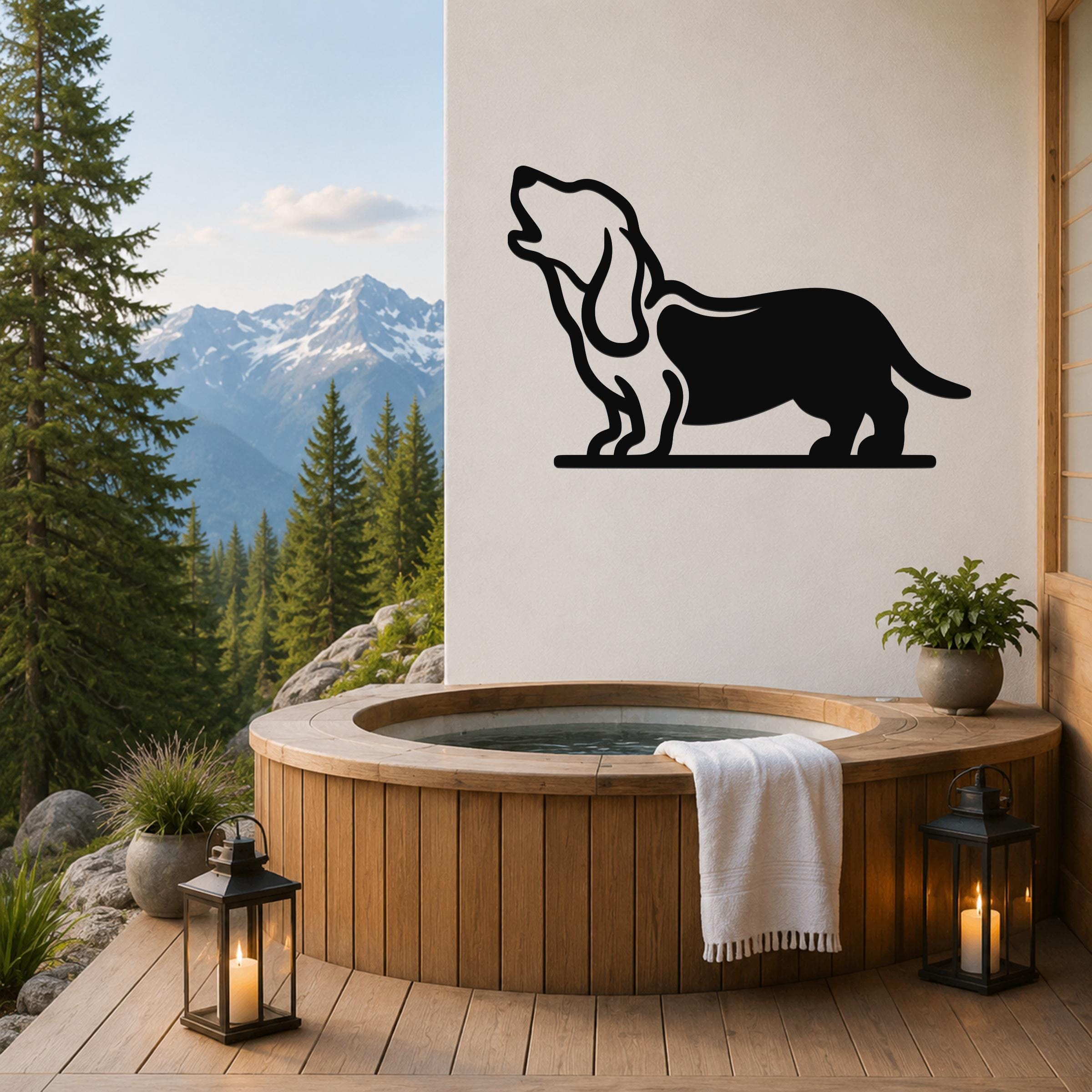 Black metal wall art of a howling basset hound silhouette, mounted on a white wall above a wooden hot tub on a mountain-view deck.