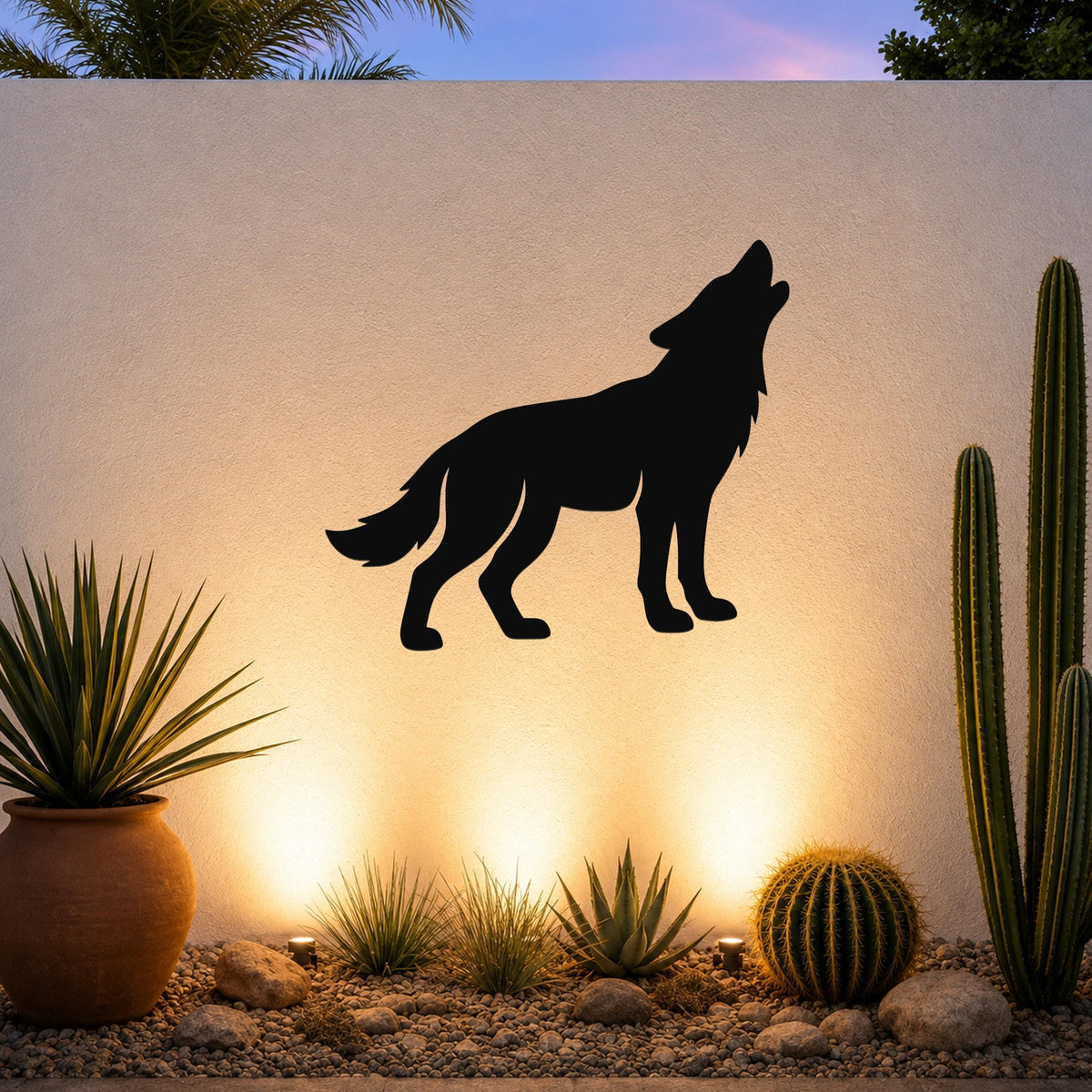 Black metal coyote silhouette wall art mounted on a textured outdoor wall above a desert garden with cacti and warm uplighting.