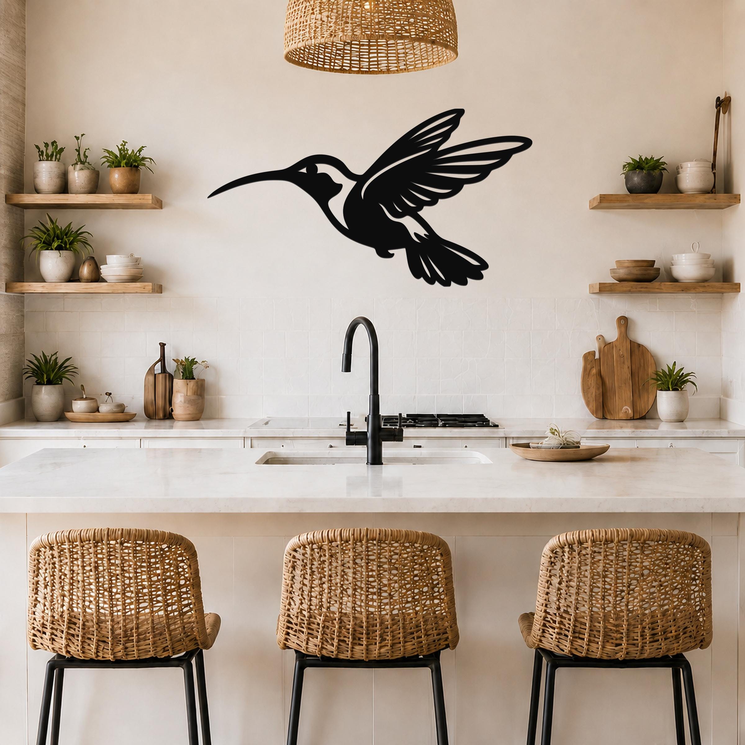 Black metal hummingbird wall art with an airy silhouette design, mounted on a kitchen wall above a counter.