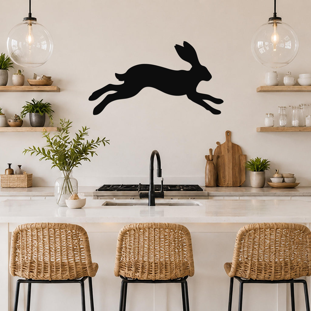 Black metal jackrabbit wall art silhouette mounted above a kitchen counter, displayed in a modern kitchen with open shelving and pendant lights.